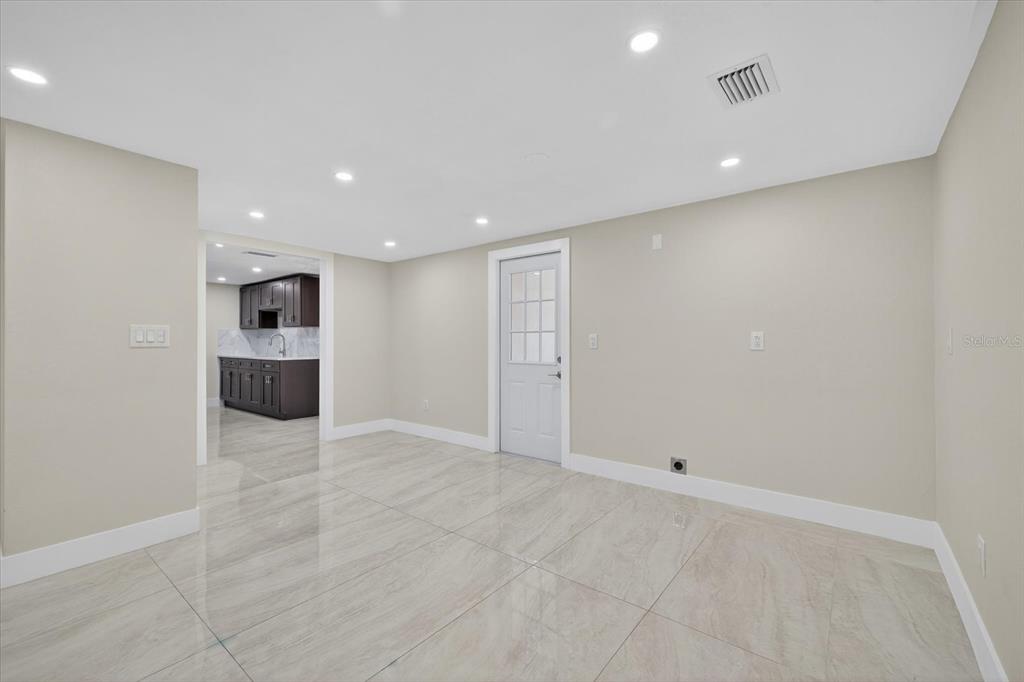 7421 Ashwood Drive Port Richey, FL 34668 - Photo 15 of 47 wooden floor in an empty room with kitchen