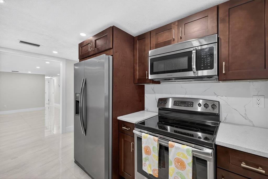 7421 Ashwood Drive Port Richey, FL 34668 - Photo 18 of 47 a kitchen with stainless steel appliances a stove microwave and refrigerator
