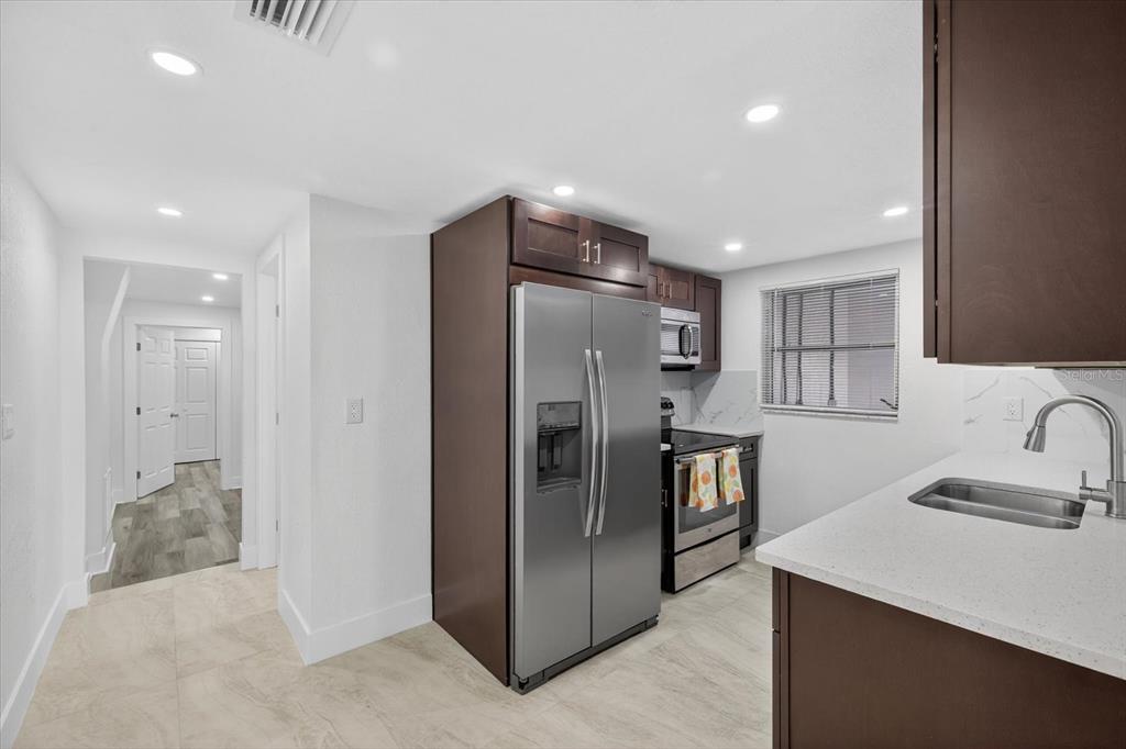7421 Ashwood Drive Port Richey, FL 34668 - Photo 19 of 47 a kitchen with stainless steel appliances granite countertop a refrigerator and a sink