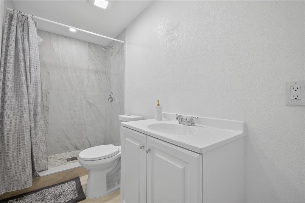 7421 Ashwood Drive Port Richey, FL 34668 - Photo 28 of 47 a bathroom with a sink a toilet and shower