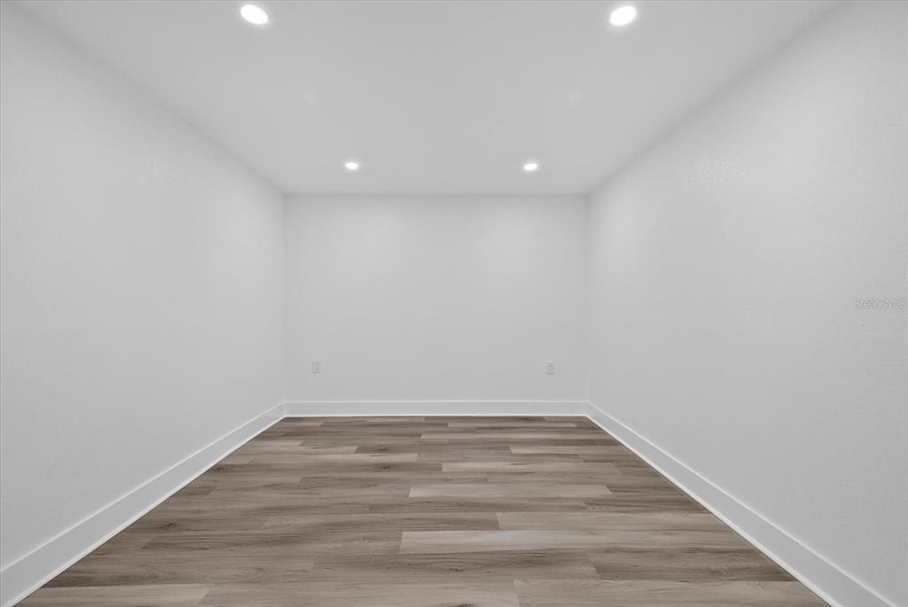 7421 Ashwood Drive Port Richey, FL 34668 - Photo 34 of 47 a view of room with wooden floor and white walls