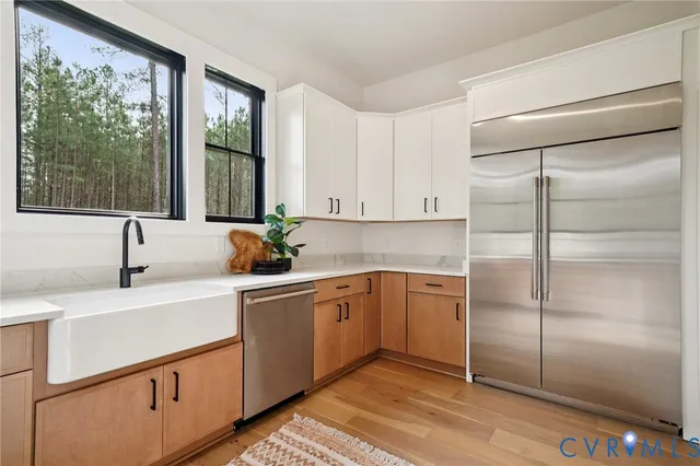 a kitchen with stainless steel appliances granite countertop a sink and a refrigerator