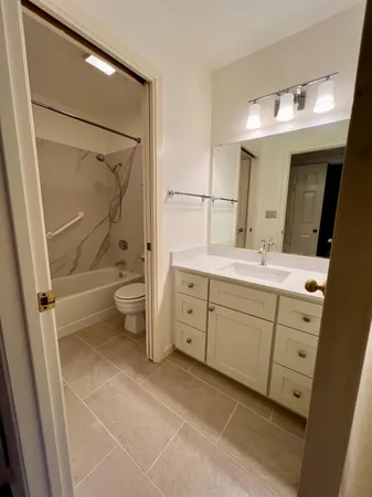 a spacious bathroom with a double vanity sink a mirror and a shower