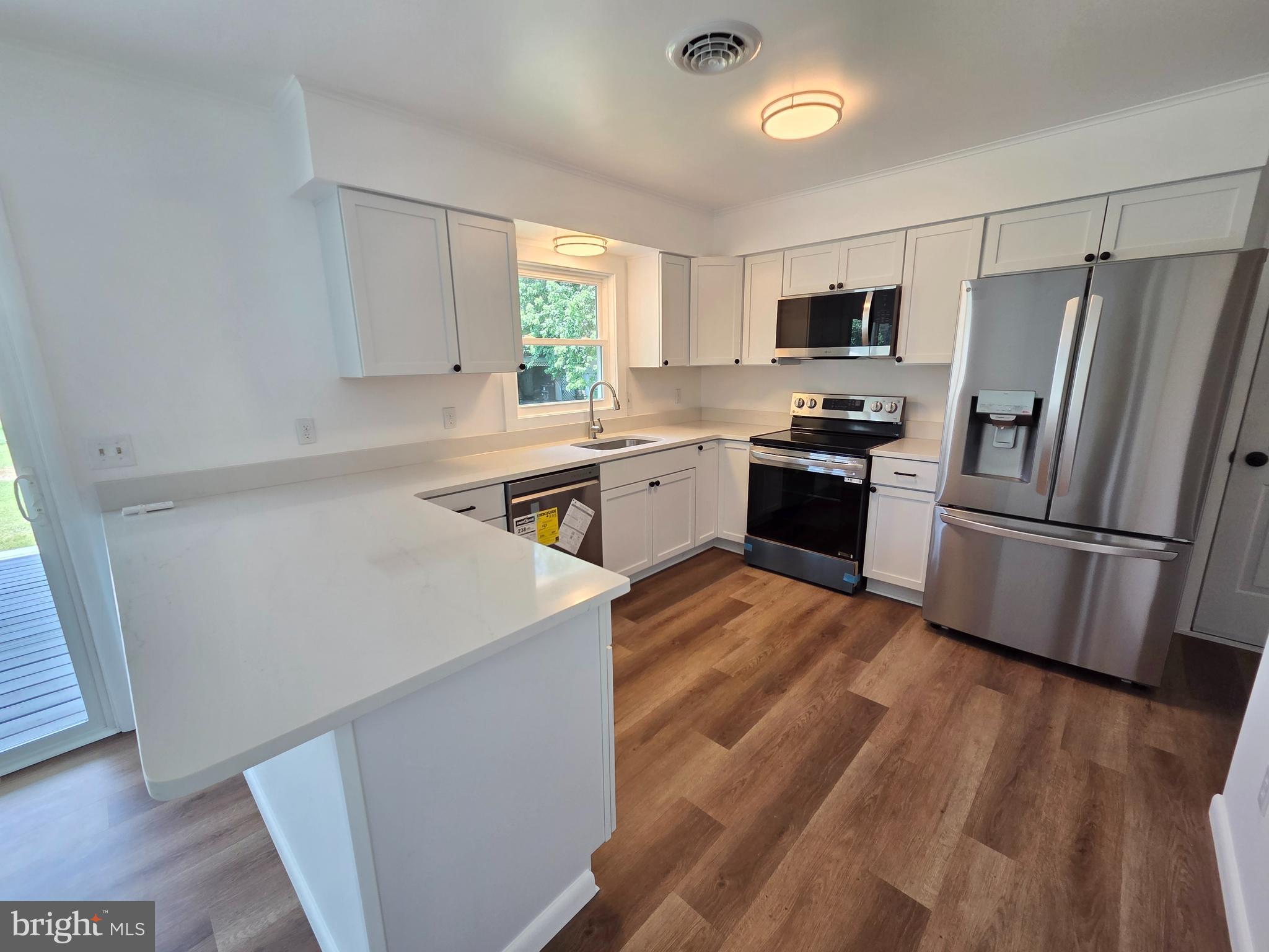 5046 Aireys Road Cambridge, MD 21613 - Photo 7 of 35 a kitchen with stainless steel appliances a refrigerator sink and stove