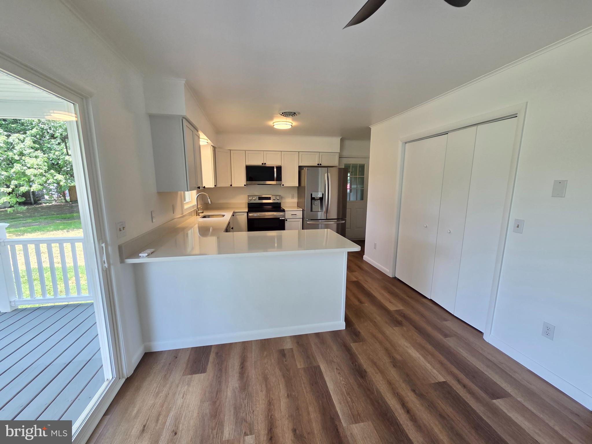 5046 Aireys Road Cambridge, MD 21613 - Photo 10 of 35 a living room with stainless steel appliances wooden floors and white walls