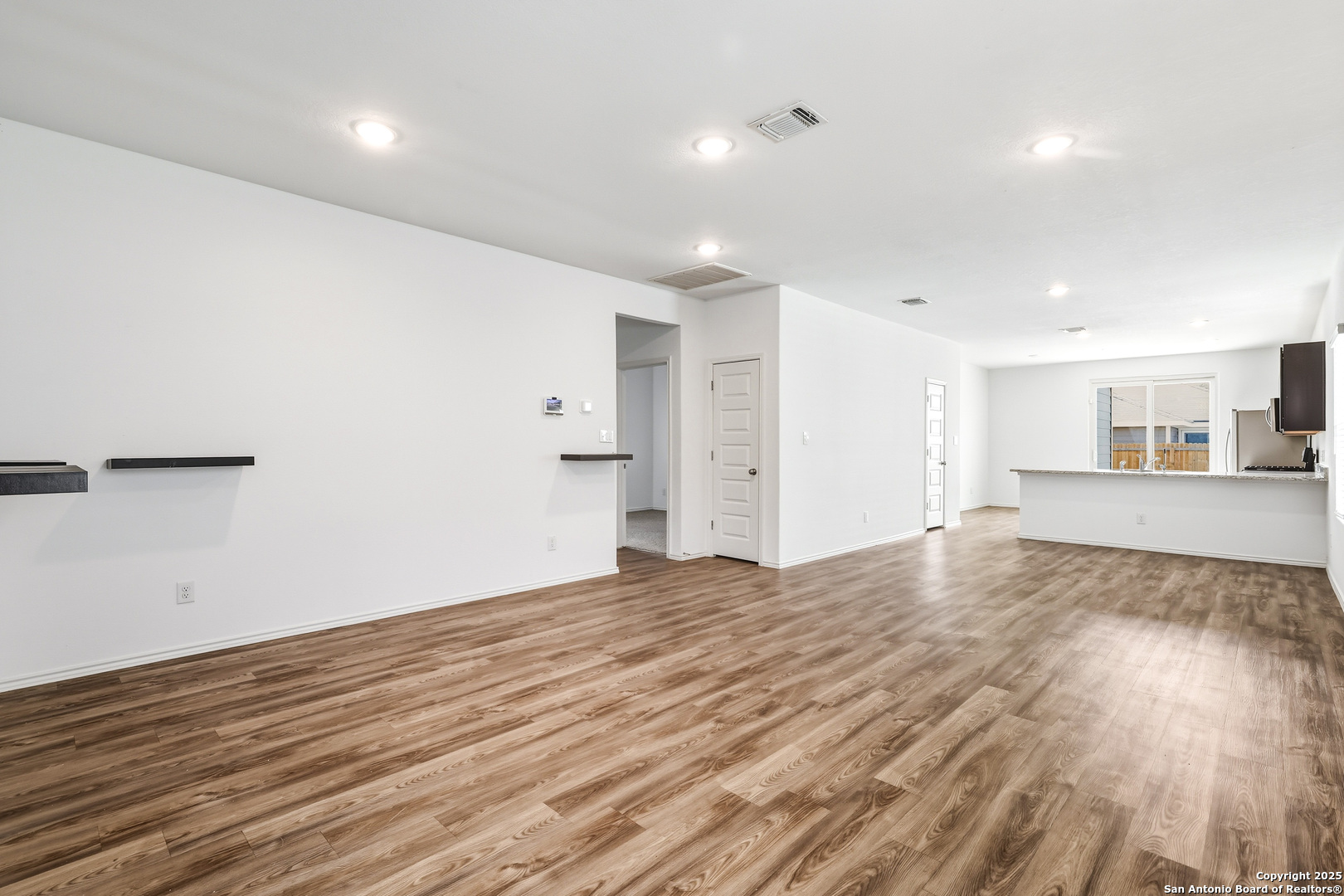 4426 Chandler Road, Unit 3 San Antonio, TX 78222 - Photo 4 of 26 a view of an empty room with wooden floor and a window