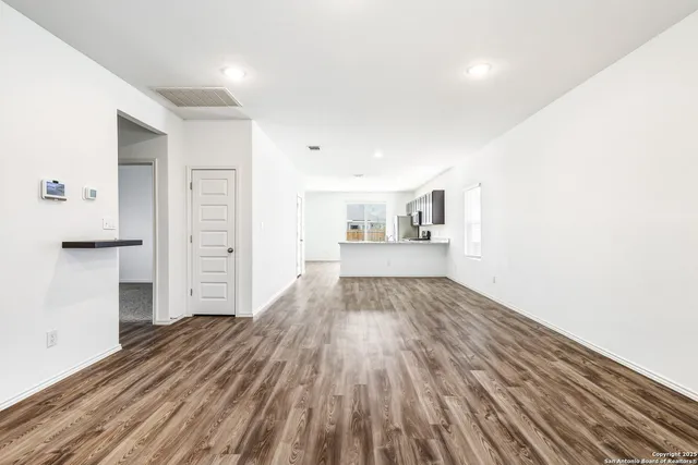 a view of empty room with wooden floor