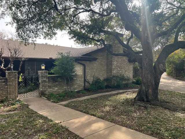 a tree in front of a white house