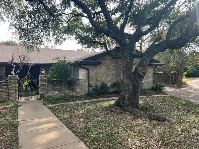 a front view of a house with a yard and tree s