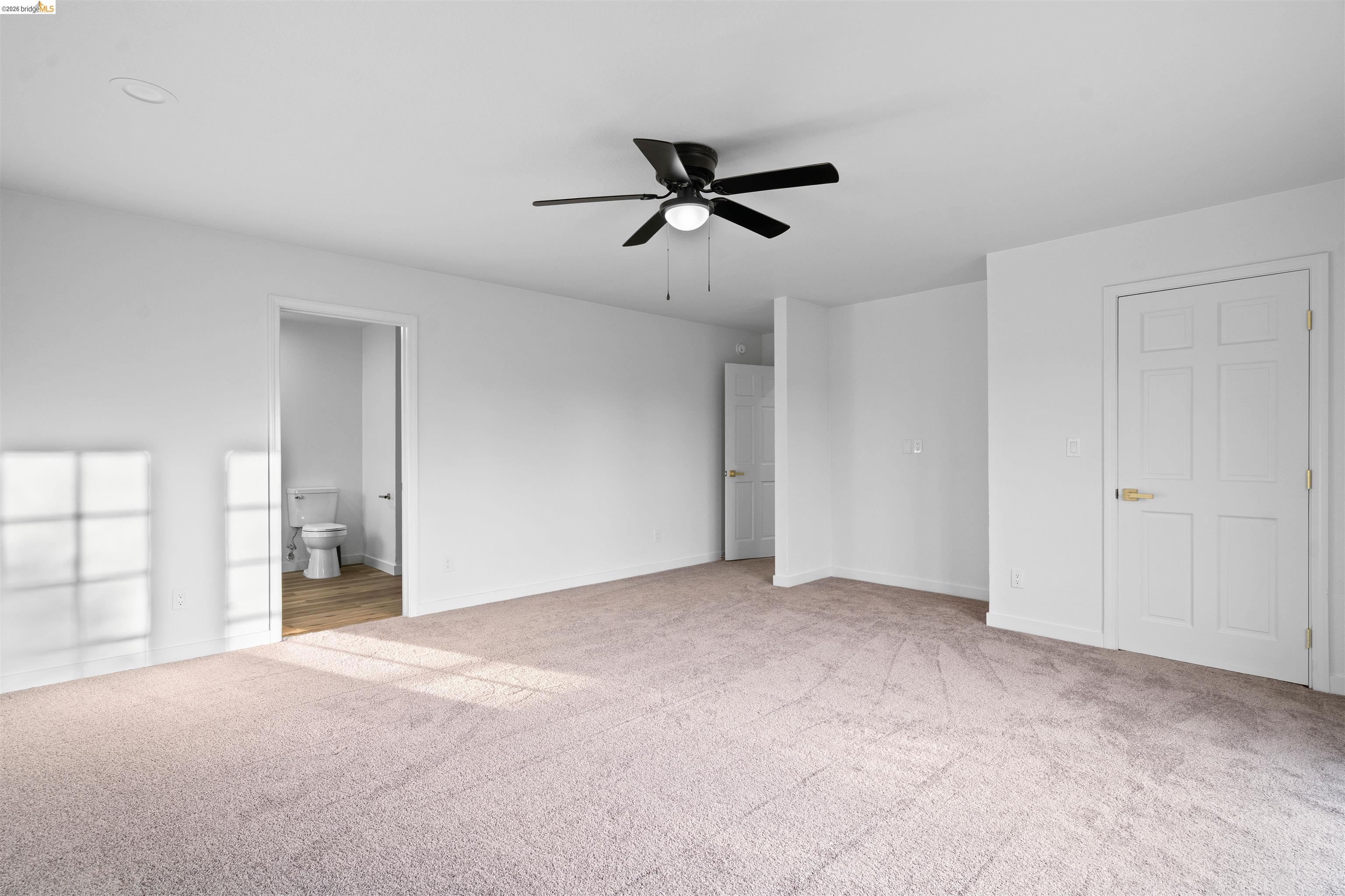 19676 Rawhide Road Sonora, CA 95370 - Photo 29 of 67 Spacious carpeted room featuring a ceiling fan, white paneled doors, and a neutral color palette