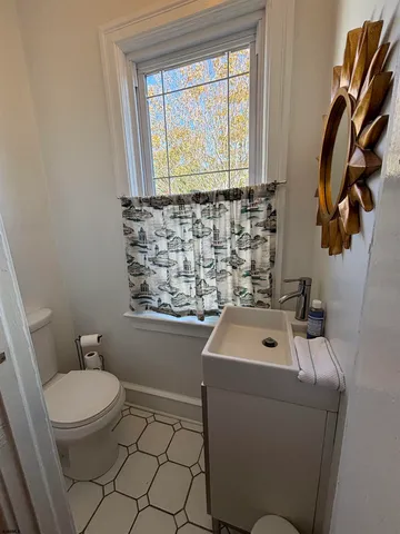 a bathroom with a sink a toilet and a window