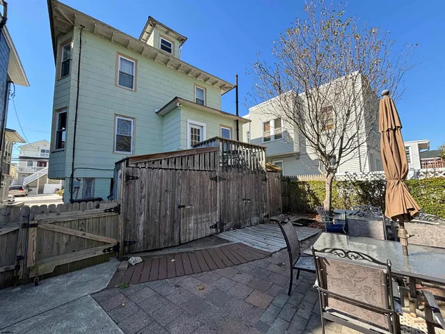a view of a patio with table and chairs with wooden fence and plants