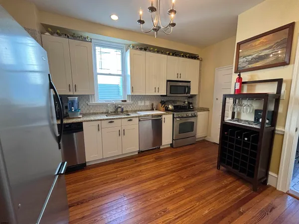a kitchen with a sink cabinets stainless steel appliances and a window