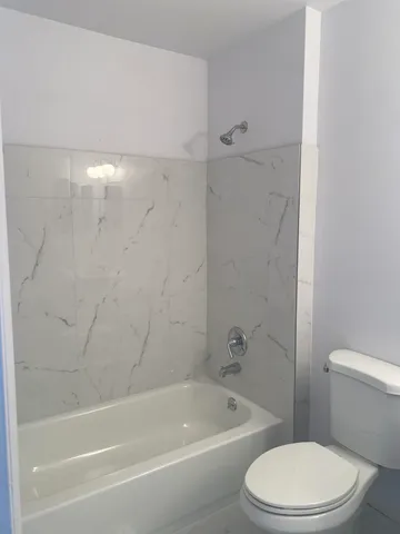 a white toilet and tub sitting next to a bathroom sink