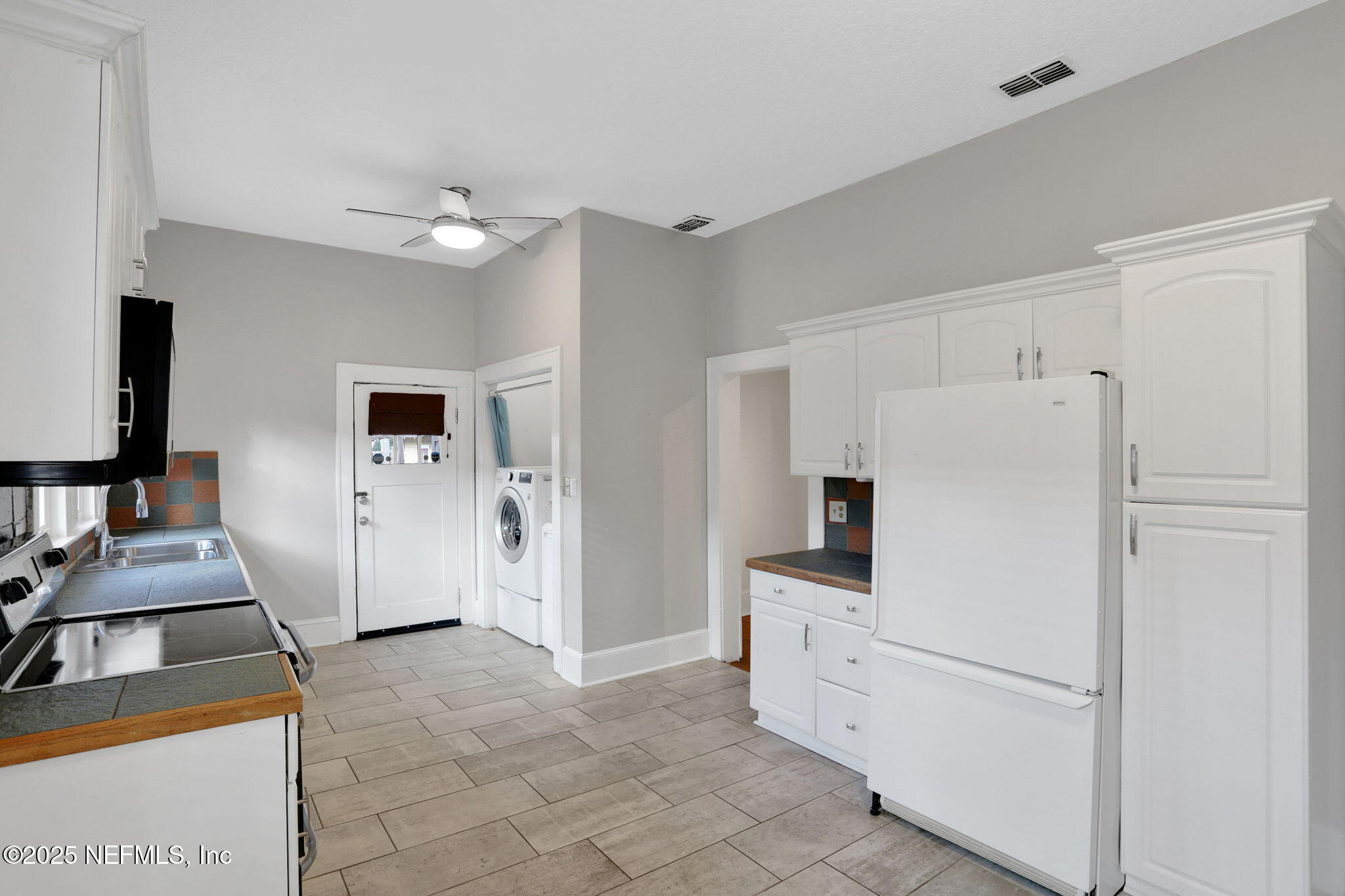 1393 Wolfe Street Jacksonville, FL 32205 - Photo 22 of 36 a kitchen with white cabinets and white appliances