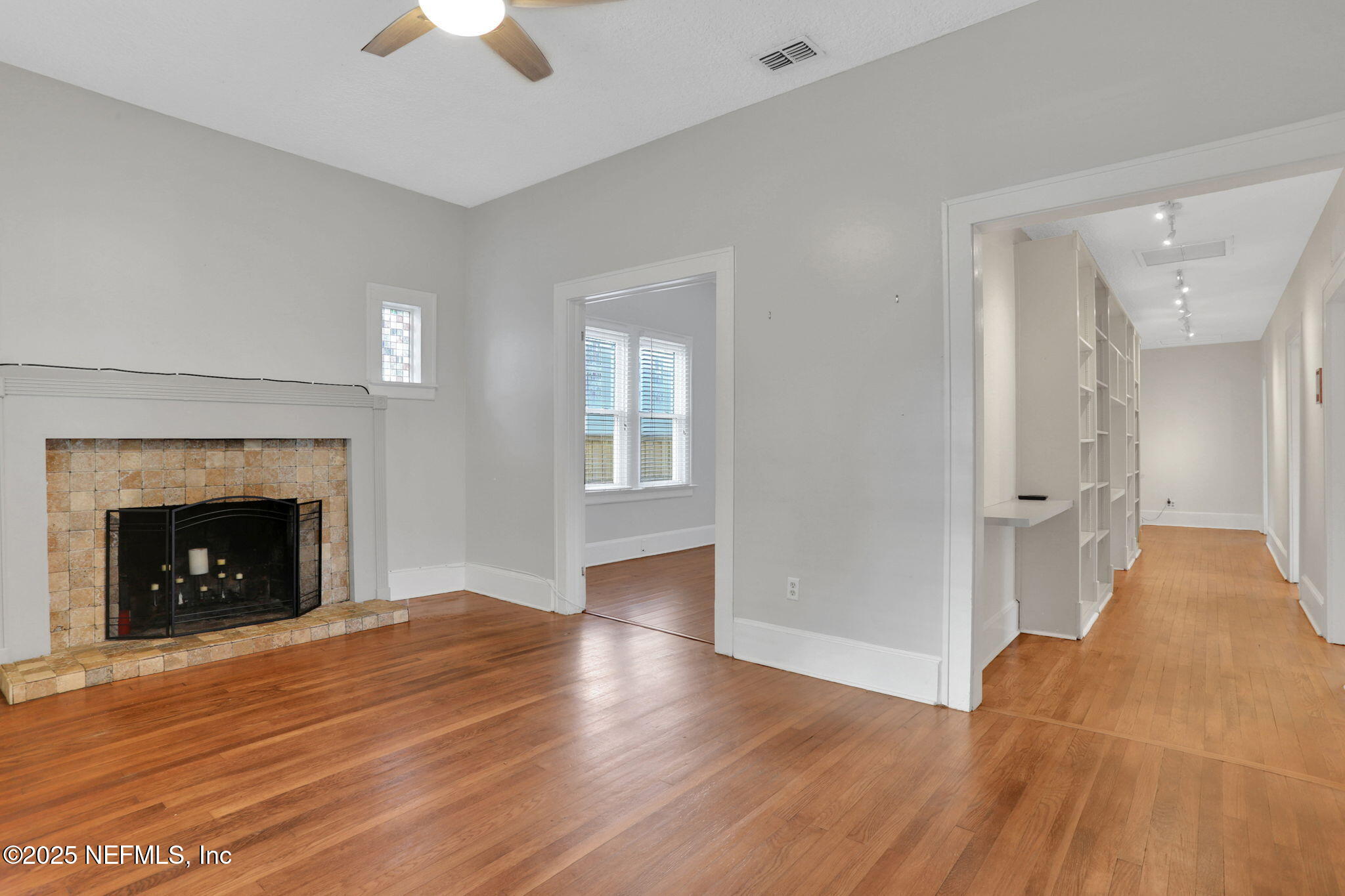 1393 Wolfe Street Jacksonville, FL 32205 - Photo 5 of 36 a view of an empty room with wooden floor fireplace and a window