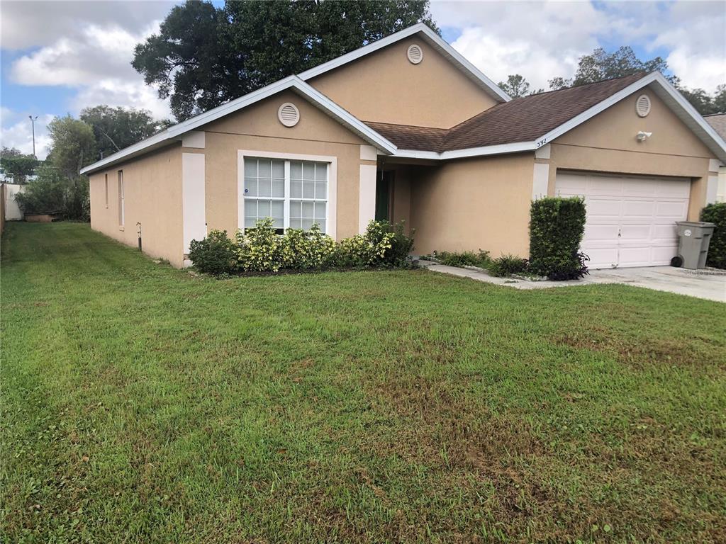 592 Rouzer Street Apopka, FL 32712 - Photo 1 of 1 a view of a yard in front view of a house and garage