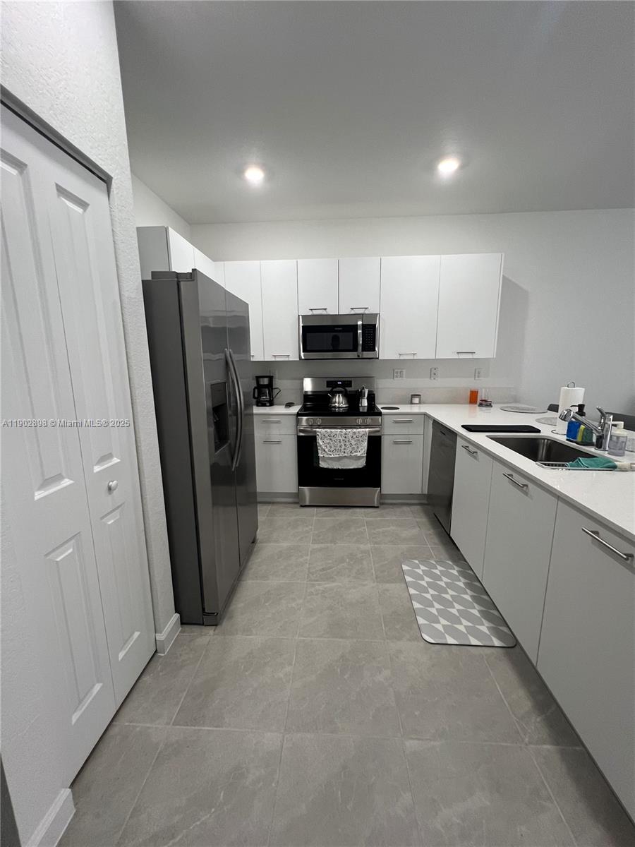 12142 Northwest 24th Court Miami, FL 33167 - Photo 20 of 20 a kitchen with refrigerator a sink and cabinets