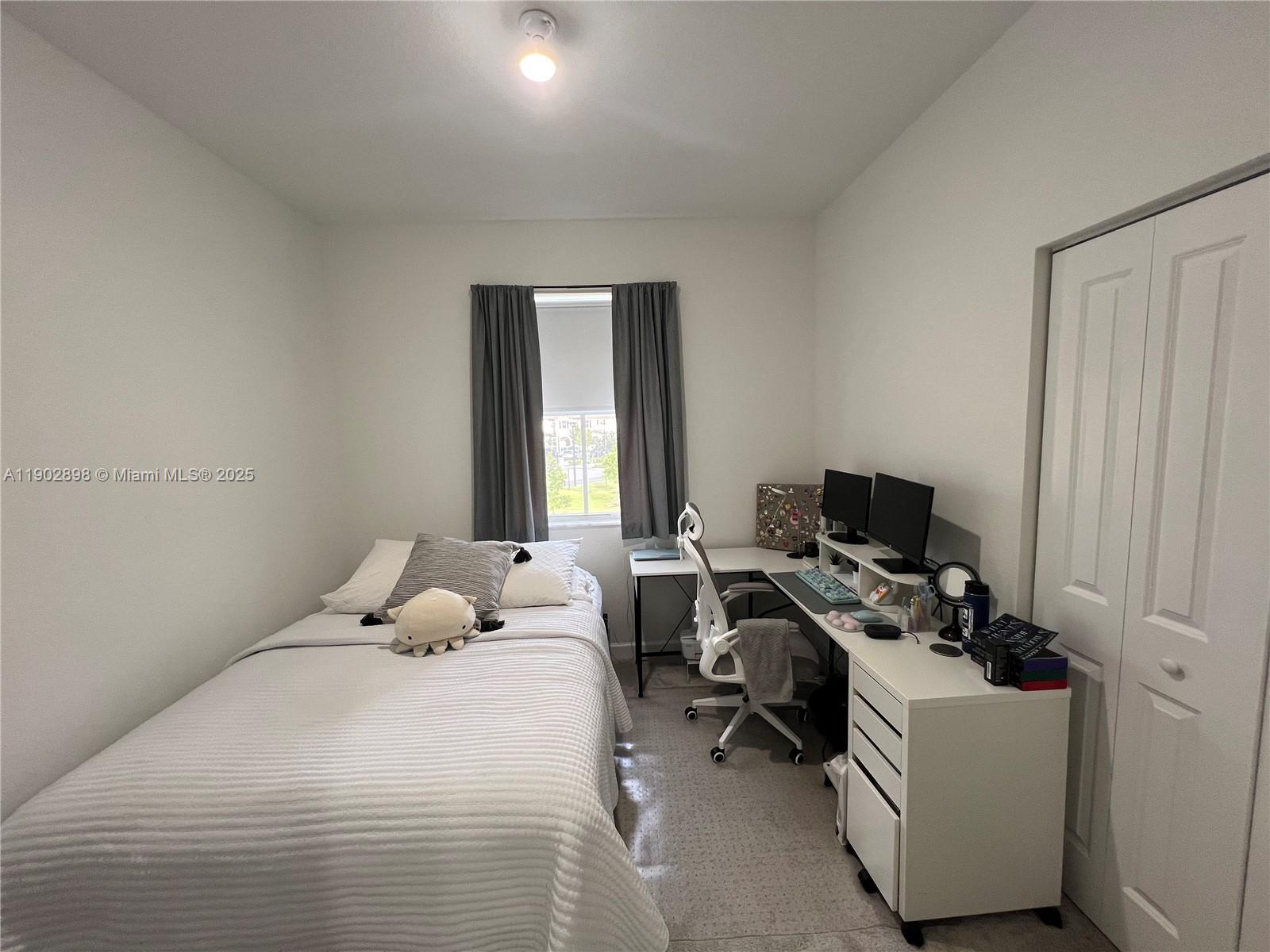 12142 Northwest 24th Court Miami, FL 33167 - Photo 10 of 20 a bedroom with a bed and a computer on the desk