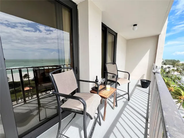 a view of a balcony dining area with furniture and floor to ceiling window