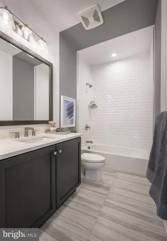 a bathroom with a granite countertop sink toilet a large mirror a bathtub and shower