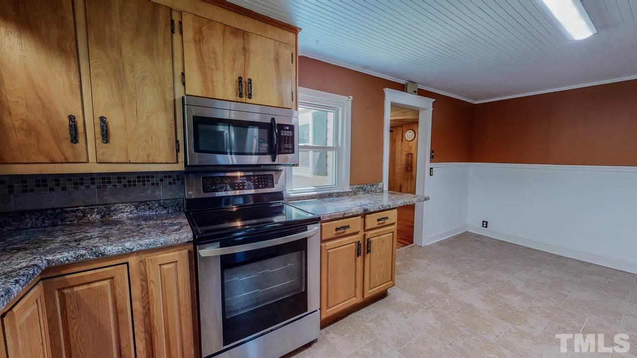 7089 Virgilina Road Roxboro, NC 27574 - Photo 12 of 28 a kitchen with stainless steel appliances granite countertop a stove microwave and cabinets