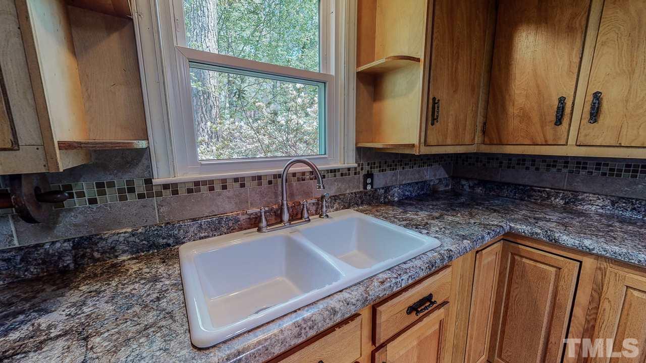 7089 Virgilina Road Roxboro, NC 27574 - Photo 13 of 28 a kitchen with granite countertop a sink and a window