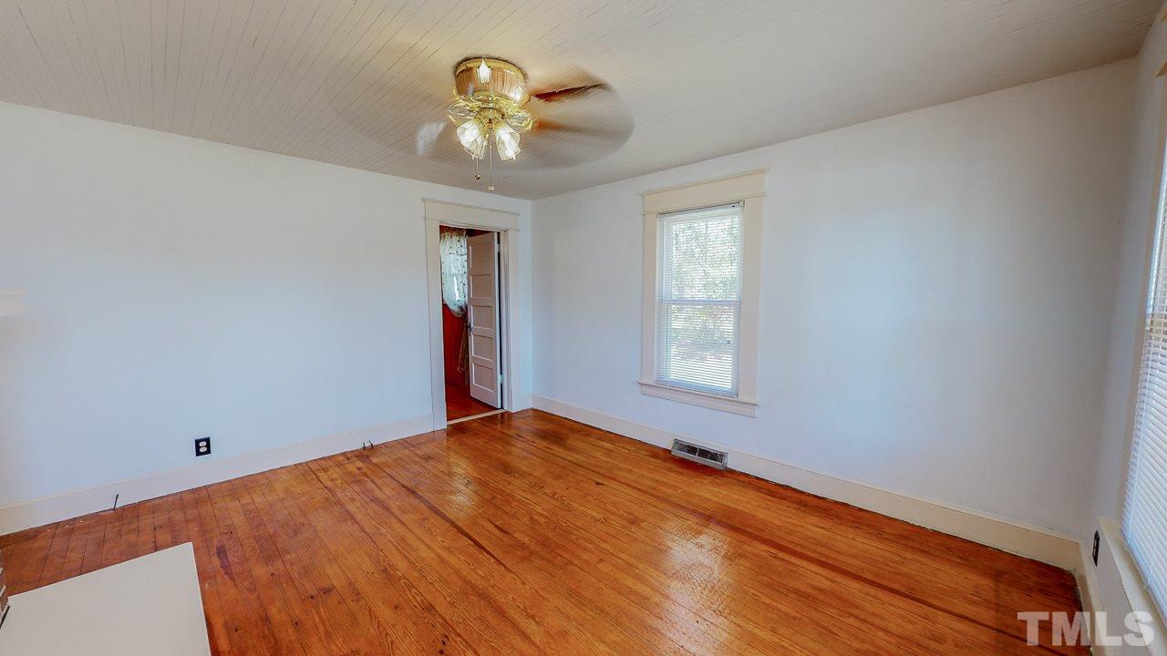 7089 Virgilina Road Roxboro, NC 27574 - Photo 14 of 28 wooden floor in an empty room with a window