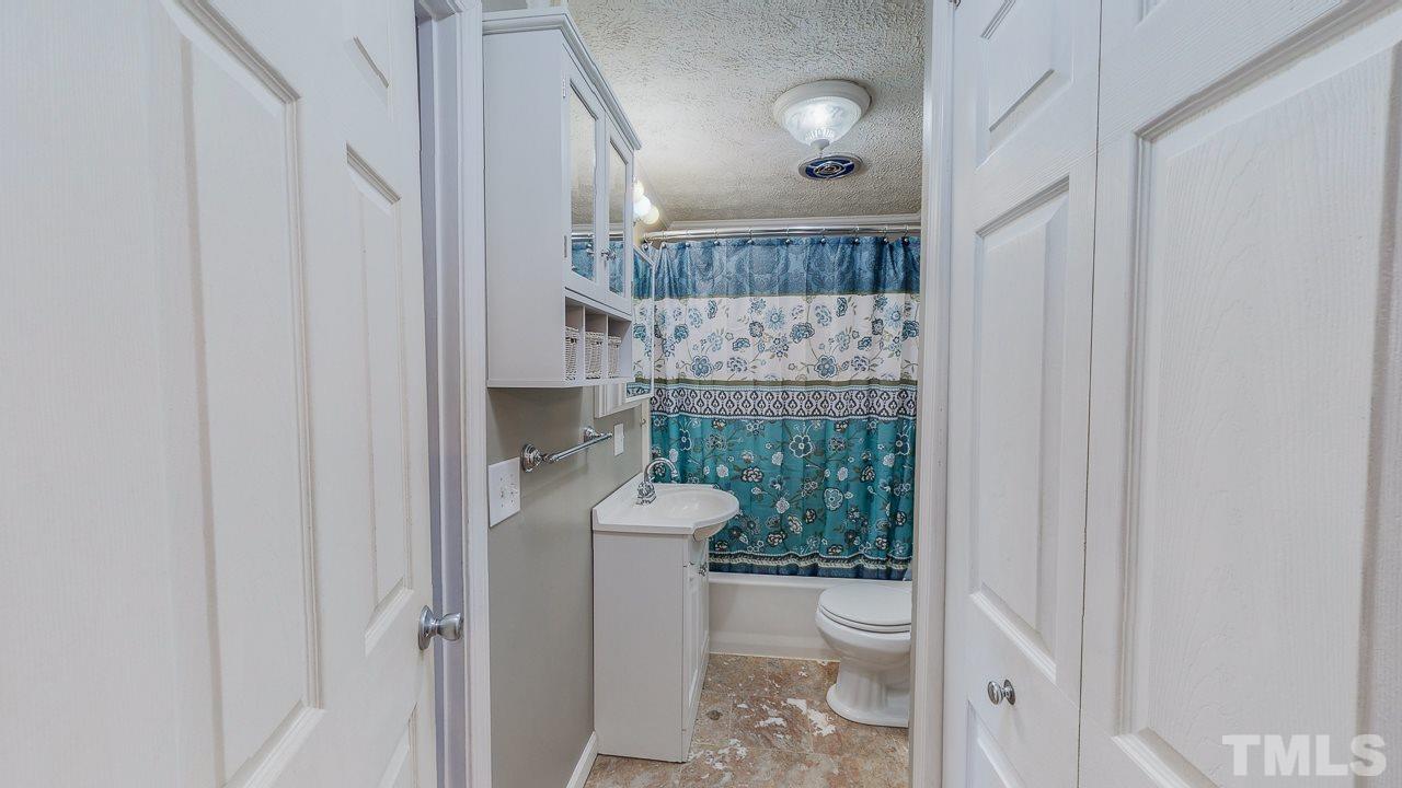7089 Virgilina Road Roxboro, NC 27574 - Photo 18 of 28 a bathroom with a toilet and a shower
