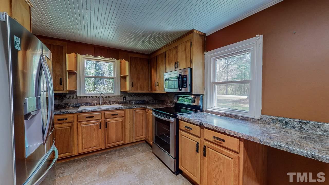 7089 Virgilina Road Roxboro, NC 27574 - Photo 3 of 28 a kitchen with stainless steel appliances granite countertop sink stove and refrigerator
