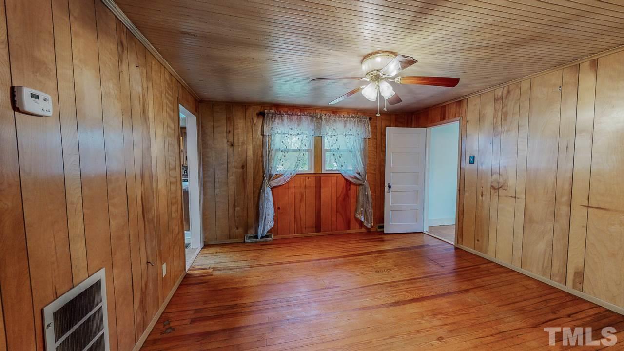 7089 Virgilina Road Roxboro, NC 27574 - Photo 21 of 28 a view of a livingroom with a ceiling fan and wooden floor