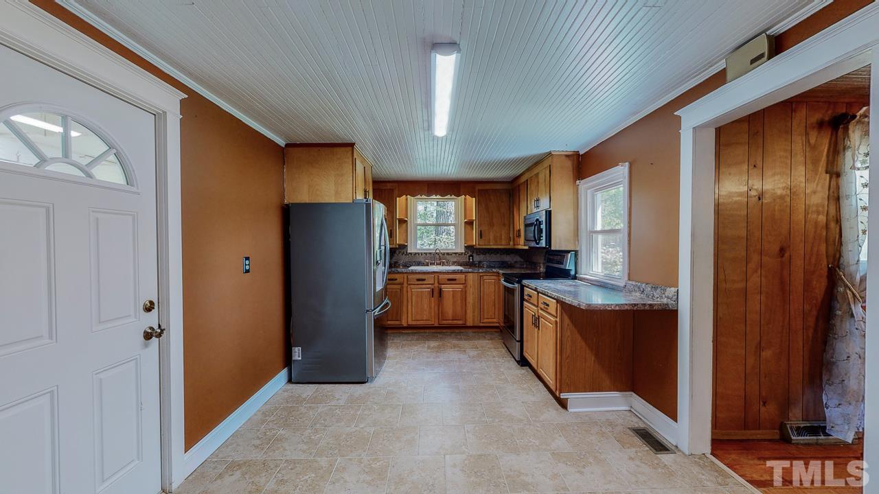 7089 Virgilina Road Roxboro, NC 27574 - Photo 4 of 28 a kitchen with a refrigerator and a sink