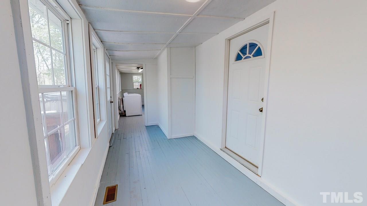 7089 Virgilina Road Roxboro, NC 27574 - Photo 9 of 28 a view of a hallway with wooden floor and a bathroom