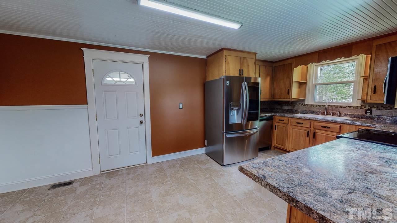 7089 Virgilina Road Roxboro, NC 27574 - Photo 10 of 28 a kitchen with stainless steel appliances granite countertop a refrigerator a sink dishwasher stove and oven