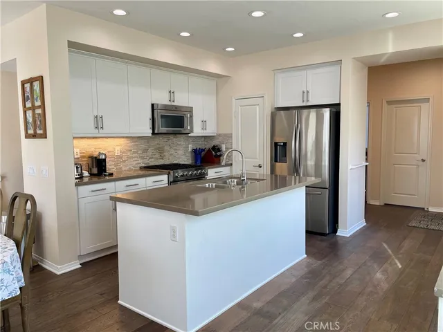 a kitchen with stainless steel appliances granite countertop a refrigerator a stove a sink and a microwave