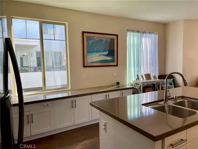 a kitchen with stainless steel appliances granite countertop a sink a stove and a granite counter tops with a large window