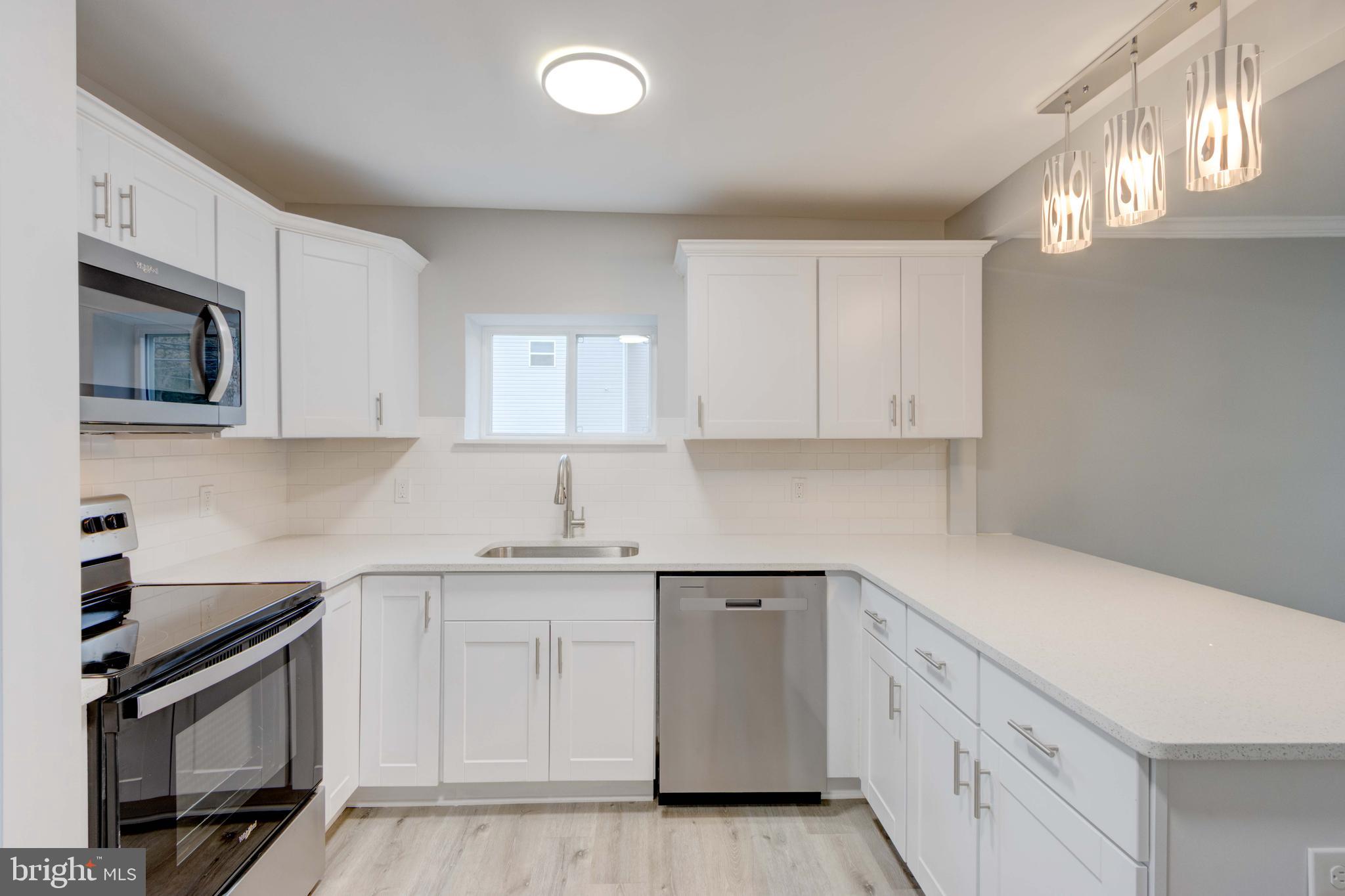8149 Hog Neck Road Pasadena, MD 21122 - Photo 11 of 24 a kitchen with white cabinets stainless steel appliances and sink