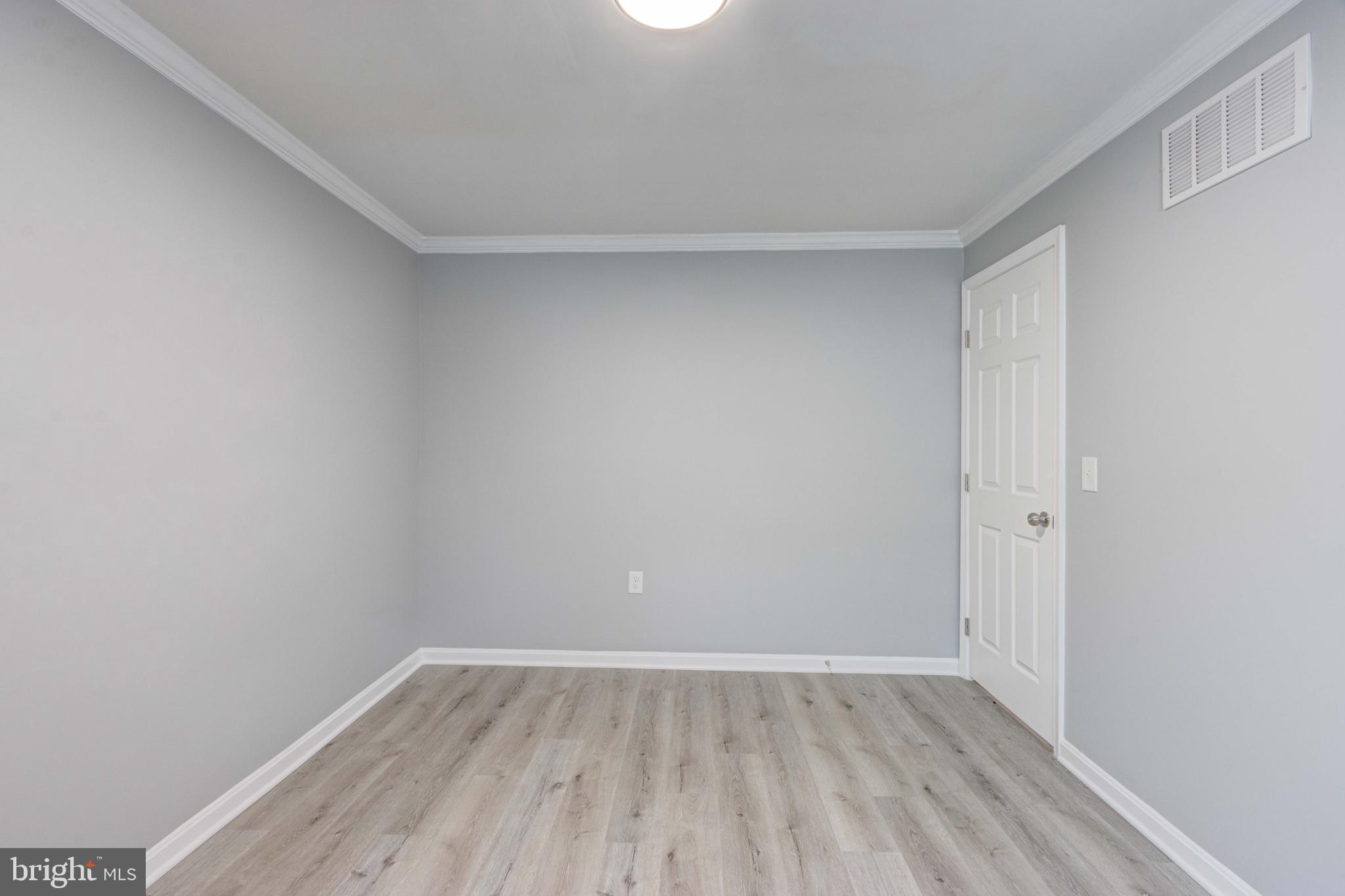 8149 Hog Neck Road Pasadena, MD 21122 - Photo 20 of 24 a view of an empty room with wooden floor and a window