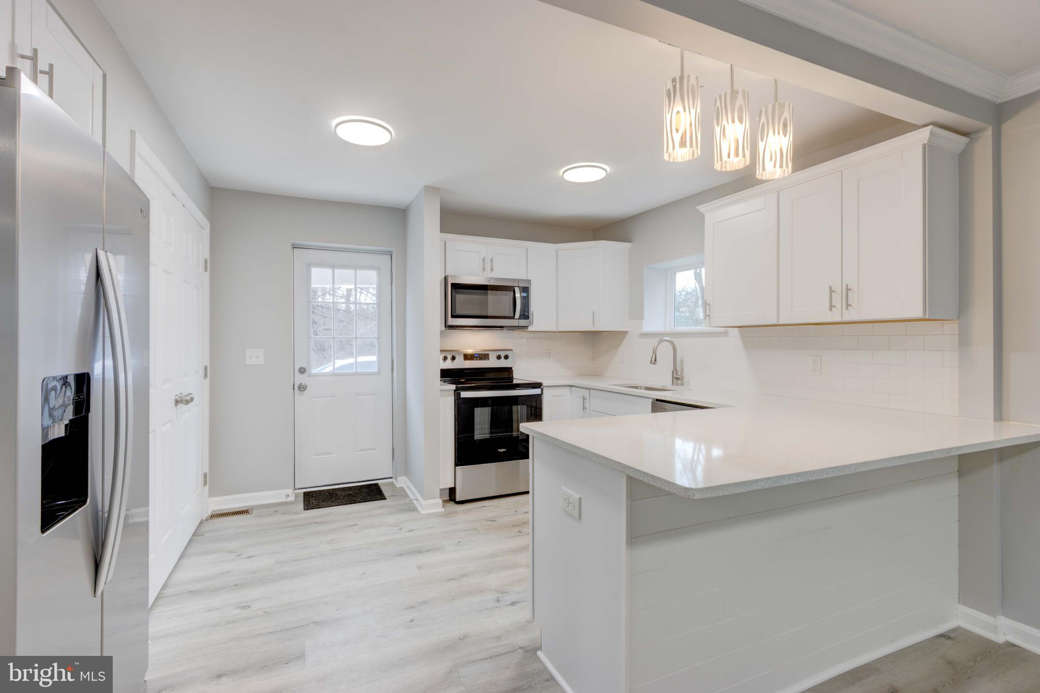 8149 Hog Neck Road Pasadena, MD 21122 - Photo 7 of 24 a kitchen with stainless steel appliances a sink stove refrigerator and cabinets