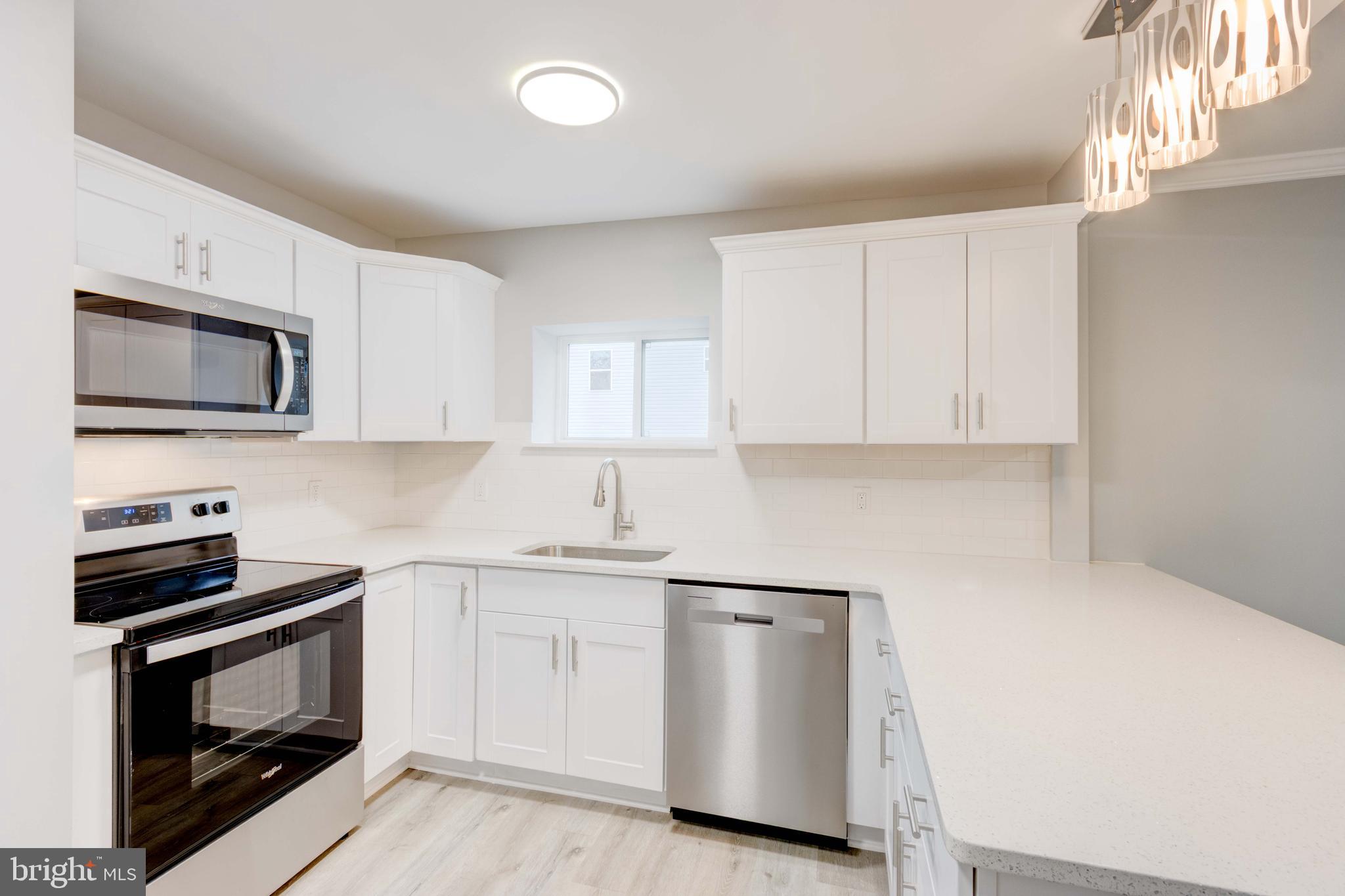 8149 Hog Neck Road Pasadena, MD 21122 - Photo 10 of 24 a kitchen with white cabinets stainless steel appliances and sink