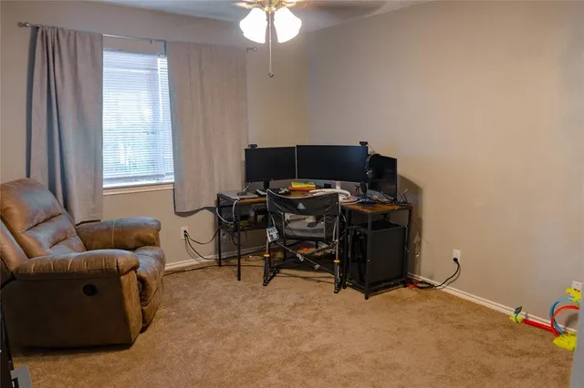 a view of a livingroom with workspace and a window