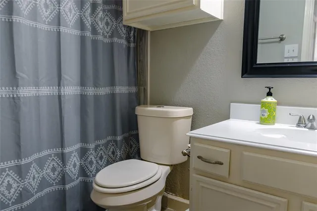 a bathroom with a toilet a sink and mirror