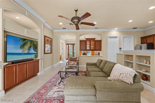a living room with furniture kitchen view and a wooden floor
