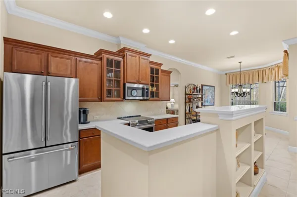 a kitchen view with stainless steel appliances granite countertop a refrigerator and a stove top oven