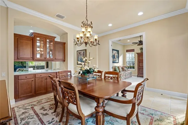 a dining room with furniture a chandelier and wooden floor