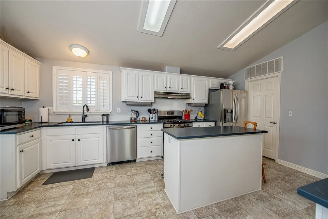 27250 Murrieta Road, Unit 304 Menifee, CA 92586 - Photo 4 of 29 a kitchen with granite countertop white cabinets and white appliances