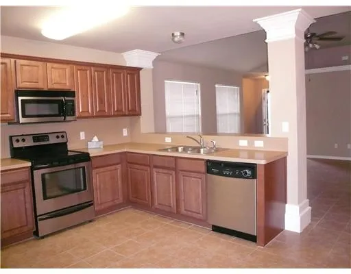 a kitchen with stainless steel appliances granite countertop a stove a sink and a microwave