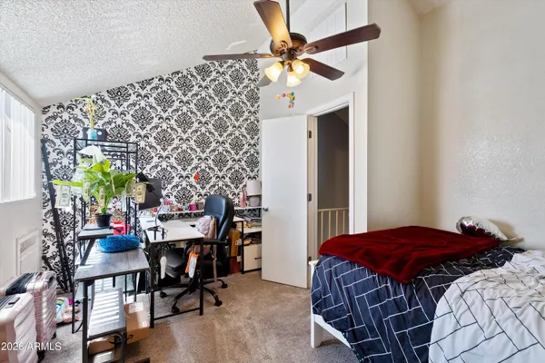 a bedroom with a bed and a chandelier