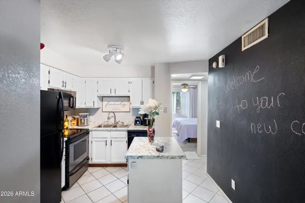 a kitchen with stainless steel appliances a refrigerator sink and white cabinets