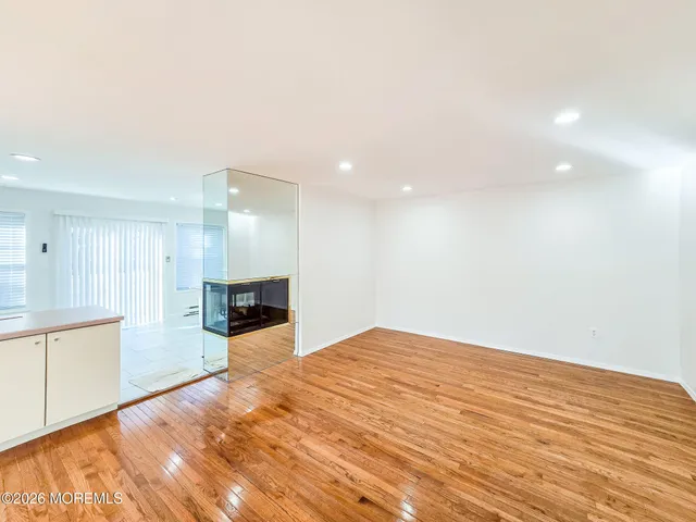 a view of empty room with wooden floor and fireplace